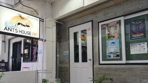 A restaurant interior with a sign for 'ANT HOUSE PP' and a poster advertising 'ANTREK' activities. - neverland hostel dorm in phi phi. (Koh Phi Phi)