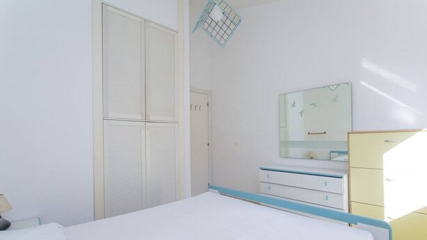 A bedroom with a bed, a dresser, a mirror, and a wardrobe. - M025 - Marcelli, three-room apartment with terrace 200 meters from the sea (Marcelli)