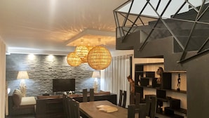 Un espace de restauration moderne avec un mur en pierre, des meubles en bois et un plafond au design géométrique.