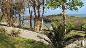 Un paisaje costero con una carretera,  árboles y vista al mar.