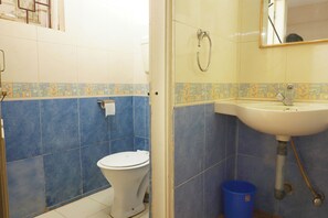 Un baño con inodoro, lavabo y azulejos azules.