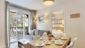 Een moderne hotelkamer met een zithoek, een bank en een balkon met zitplaatsen.