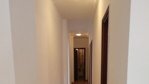 A narrow hallway with wooden flooring and white walls, leading to a door at the end. - Centric Three Bedroom Flat in Santa Cruz 5B (Santa Cruz de Tenerife)