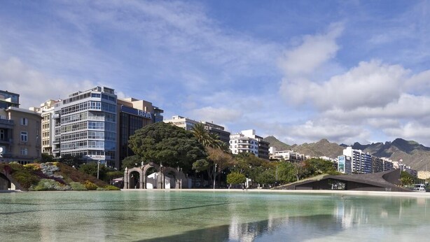 A coastal cityscape with modern buildings, a clear sky, and a calm waterfront. - Centric Three Bedroom Flat in Santa Cruz 5B (Santa Cruz de Tenerife)
