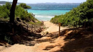 A dirt path leading to a beach with a fence on one side and trees on the other. - Cozy & Contemporary Stay (Cavalaire sur Mer)