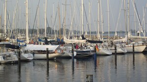 A marina with multiple sailboats docked. - Immediately on the beach! (Kiel)
