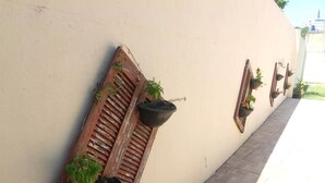 Un mur avec des volets en bois et des jardinières suspendues.