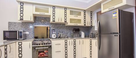 Deluxe Apartment, 3 Bedrooms | Private kitchen | Full-size fridge, oven, stovetop, electric kettle