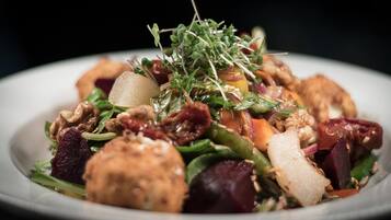 Ensalada con diversas verduras y brotes sobre un plato.