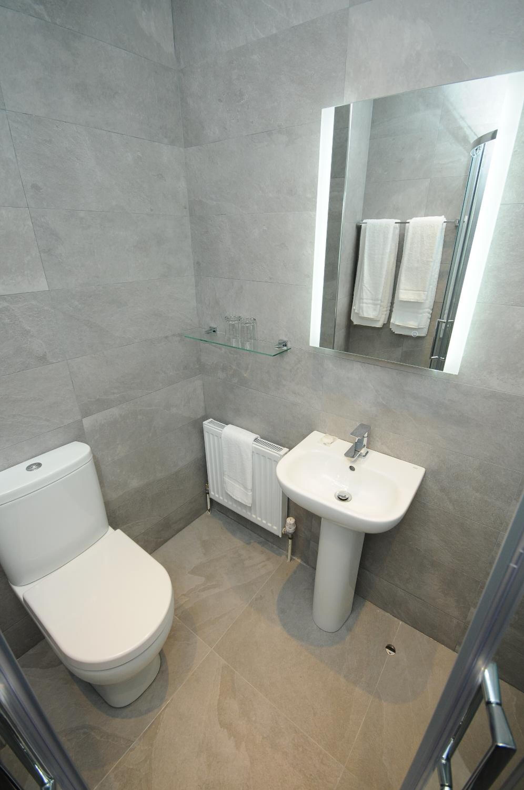 Ein modernes Badezimmer mit Toilette, Waschbecken und Duschkabine.