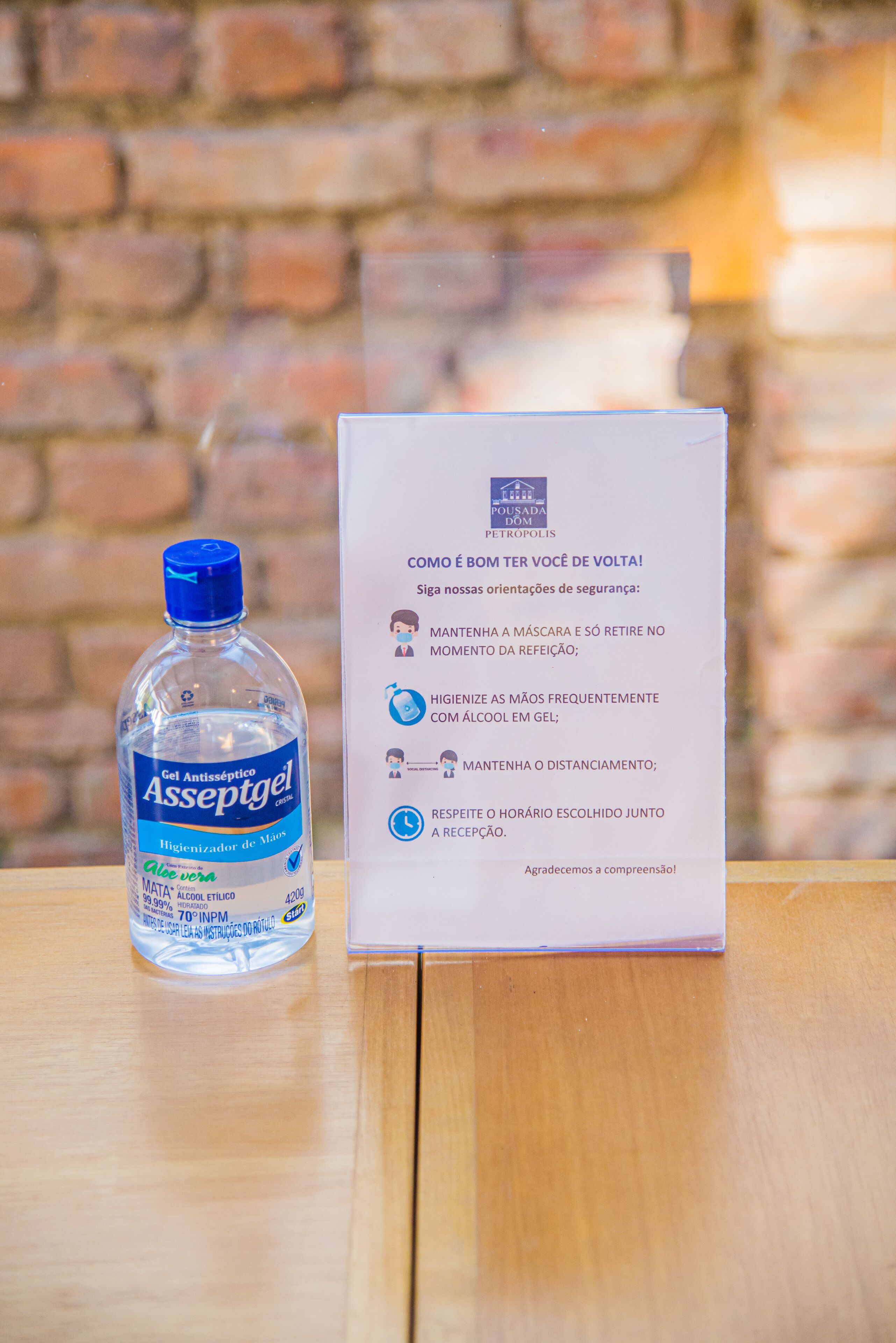 A bottle of Asseptgel hand sanitizer and a sign with safety guidelines.
