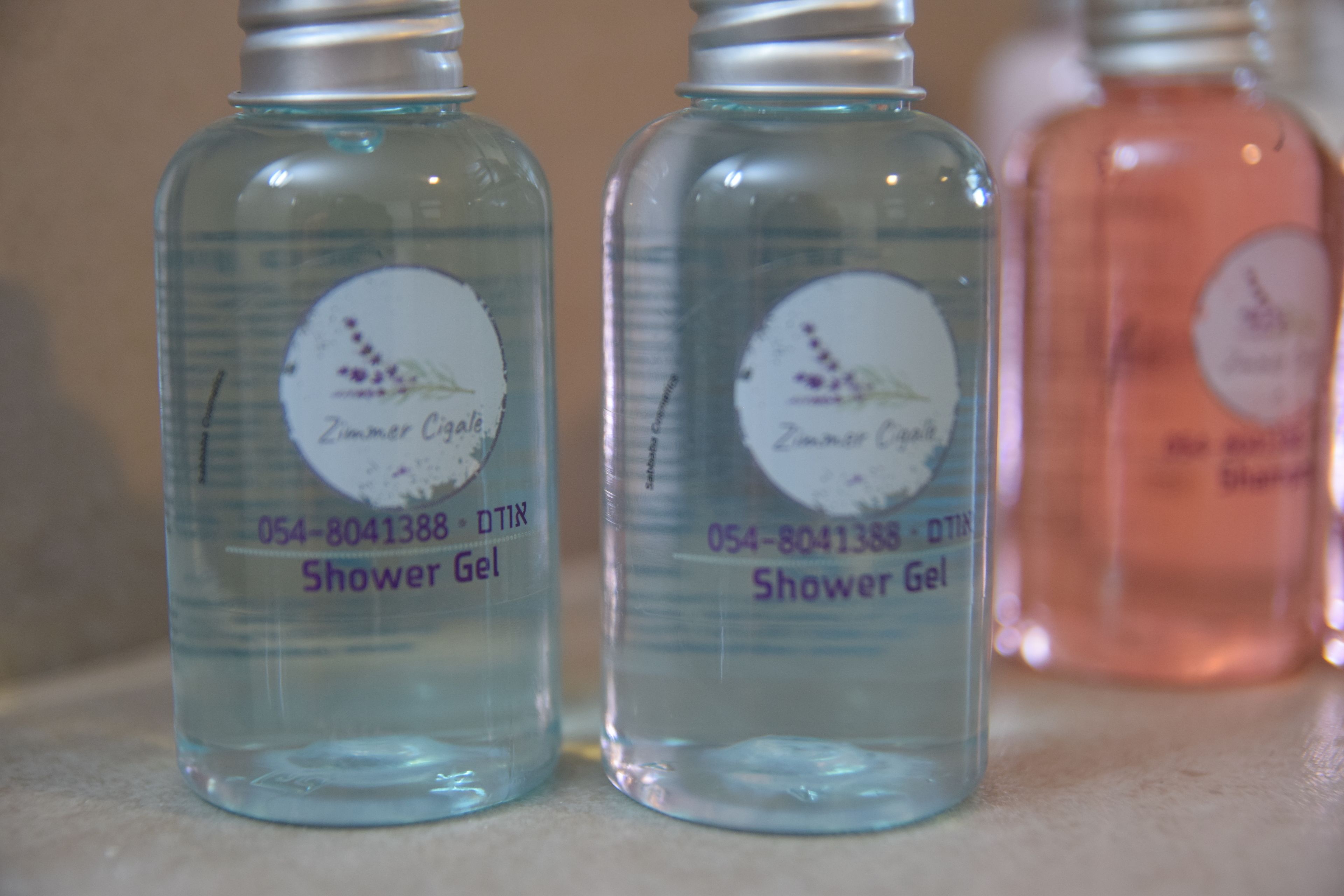Tres botellas de gel de ducha sobre una encimera.