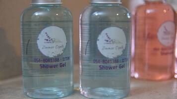 Tres botellas de gel de ducha sobre una encimera.