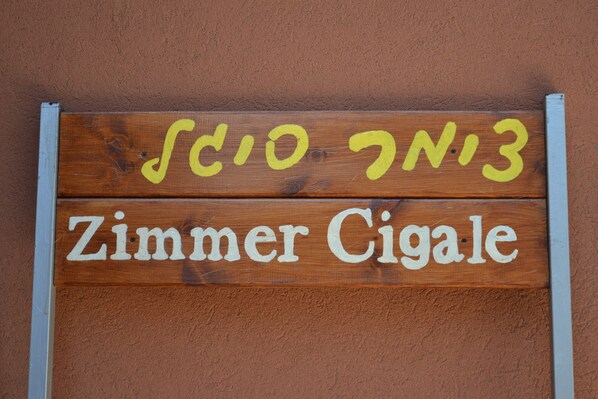 Un letrero de madera con el texto 'Zimmer Cigare' y 'Scio 7N13' pintado en amarillo y blanco.