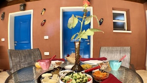 Una mesa de vidrio redonda con diversos alimentos y un centro de mesa decorativo con una planta.
