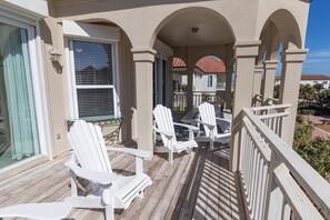 Relax on the balcony with two Adirondack chairs and a small table.