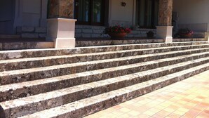 A building with stone steps leading to a porch with columns and potted plants. - Luxurious villa Maremonti (Canicattini Bagni)