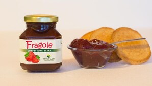 A jar of Fragole confettura extra with a spoonful of jam and two slices of bread. - B&B Agriturismo Lake Iseo and Franciacorta in the countryside - Mora (Paratico)