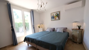 A bedroom with a bed, a chandelier, a painting, a nightstand, and a cabinet. - Vacation rental house with pool MOURIES LS1-308 (Mouriès)