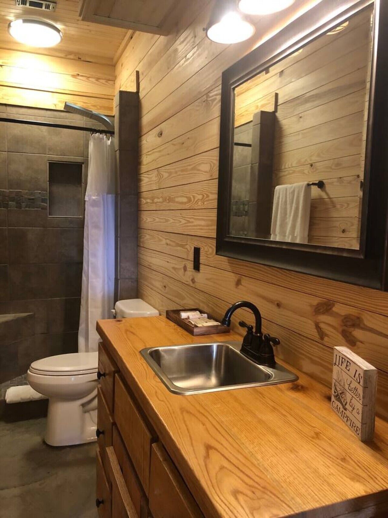 Un intérieur en bois avec une douche, des toilettes et un lavabo.