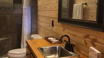 Un intérieur en bois avec une douche, des toilettes et un lavabo.