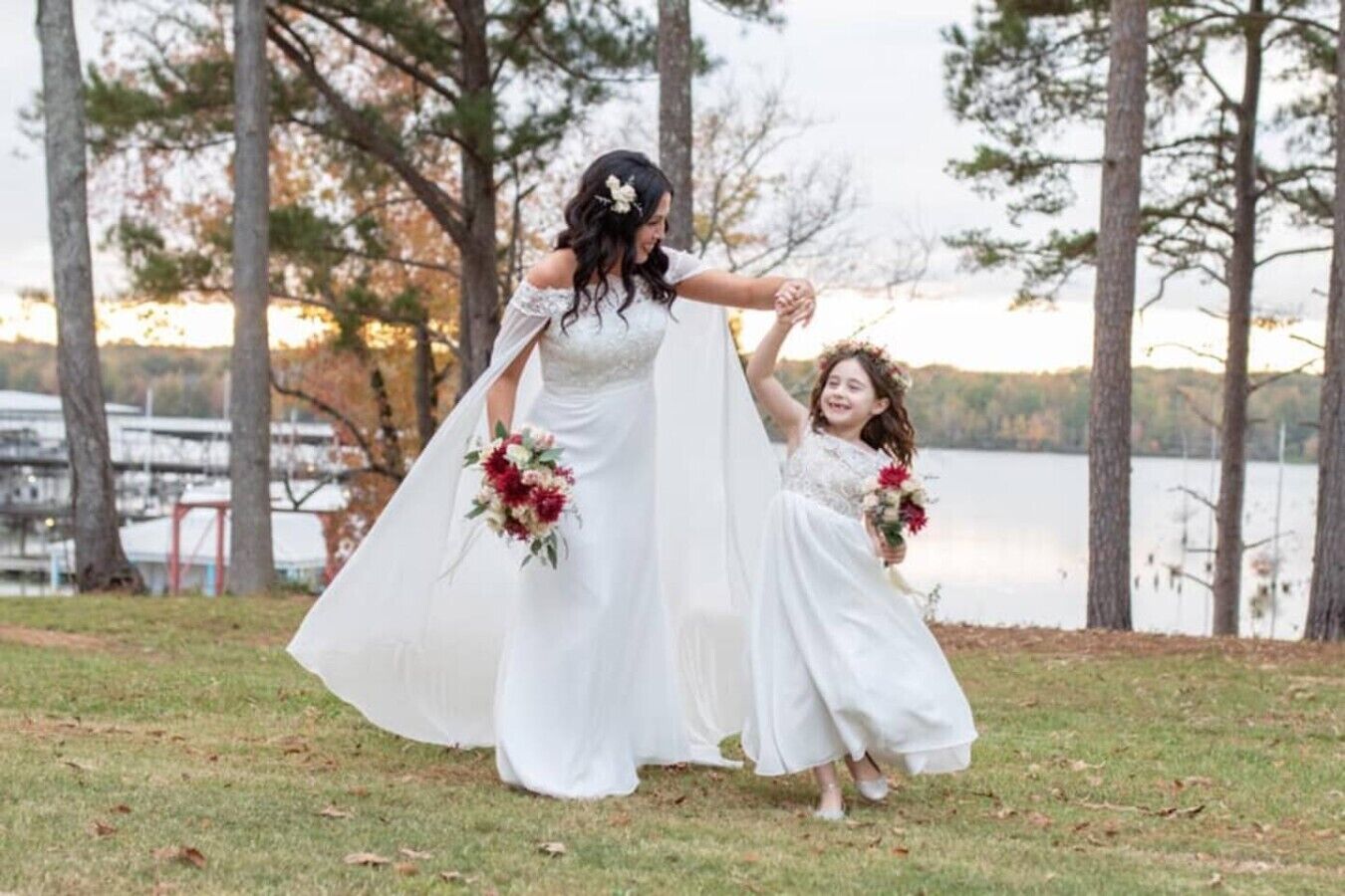 A wedding scene with a bride and two flower girls by a lake.
