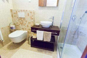 A bathroom with a toilet, sink, and shower.