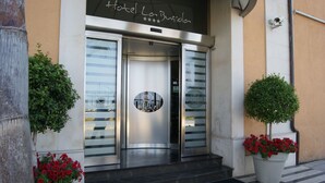 The entrance to Hotel La Bussole with a modern design, featuring a glass door and a metal frame. - La Bussola Hotel (Milazzo)
