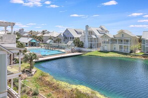 A residential area with a swimming pool, multiple houses, and a water body. - Fab Beach Home w/ Spacious Primary Suite & Access to Countless Amenities (Port Aransas)