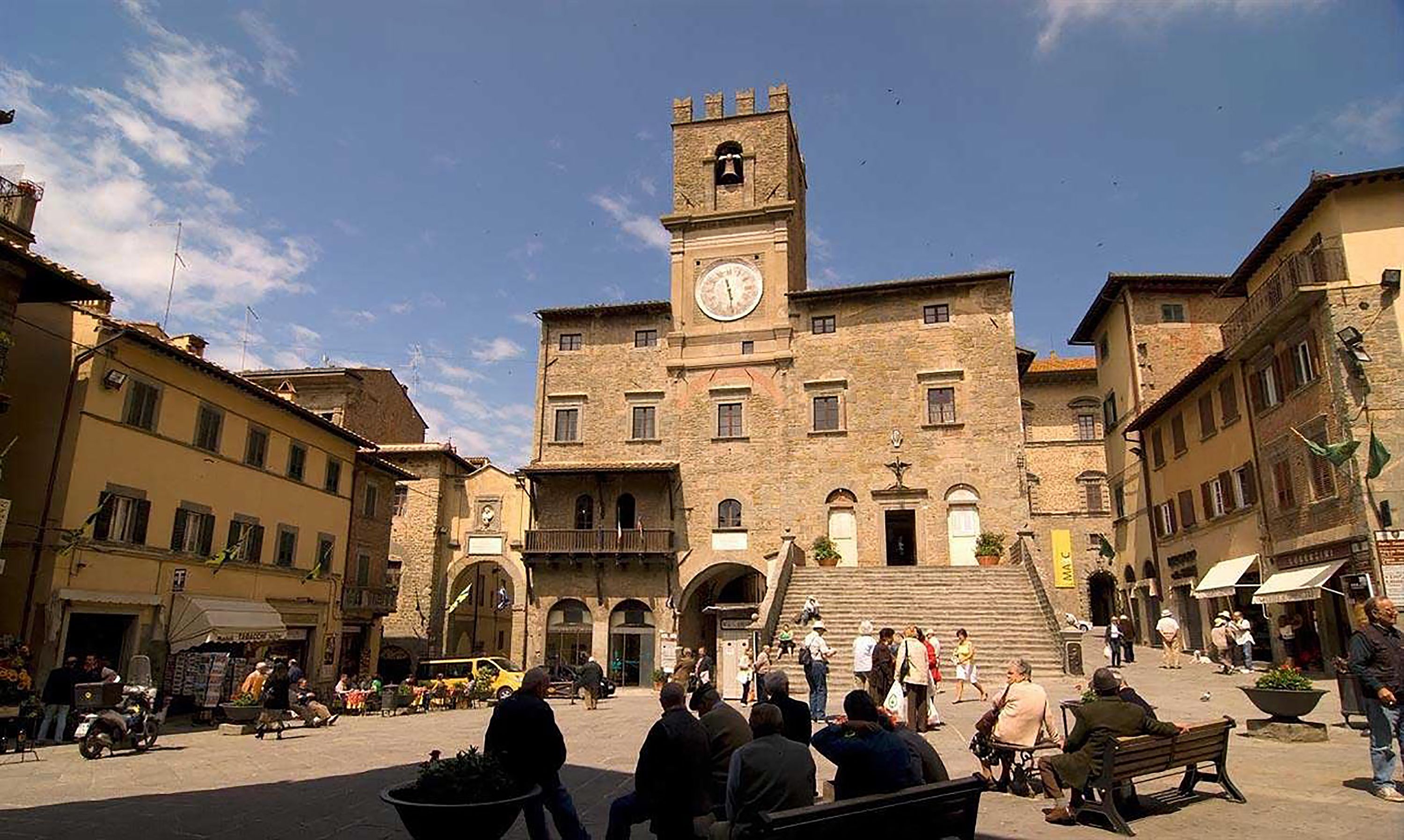 A historic building with a clock tower, a central courtyard, and surrounding traditional architecture.