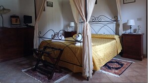 Ein Bett mit Baldachin, ein Nachttisch mit Lampe und ein weiterer Nachttisch mit Lampe.