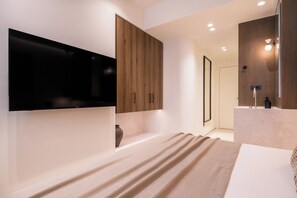 Ein modernes Badezimmer mit einem großen Spiegel, einem Flachbildfernseher und einem Holzbadezimmerkorpus.
