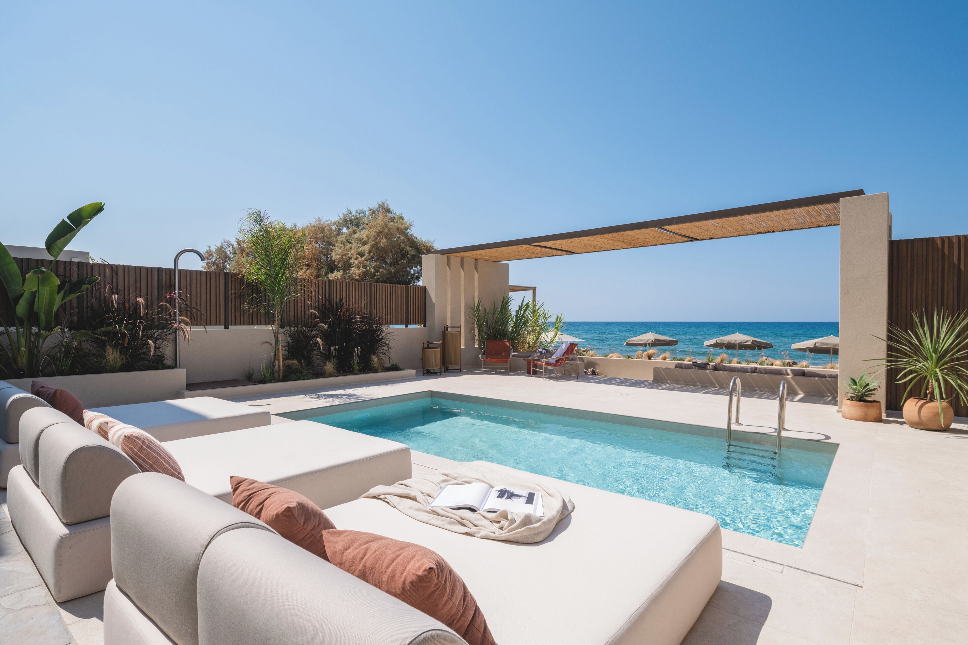 Un espace piscine avec des chaises longues et vue sur la mer.