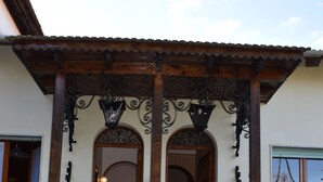 A building with a wooden porch, marble stairs, and potted plants.