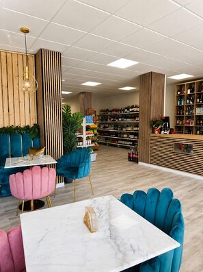 Un intérieur moderne avec un bar, des sièges confortables et une étagère bien garnie de boissons alcoolisées.
