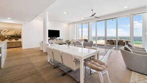 A modern dining area with a large table, chairs, and a view of the outdoors.