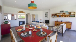 Un comedor con una mesa roja, varias sillas y una variedad de platos.