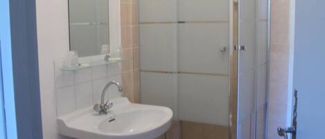 Une salle de bain avec une douche à parois de verre, un lavabo et des toilettes.