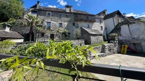 Un bâtiment traditionnel en pierre, doté de nombreuses fenêtres et d’un balcon.
