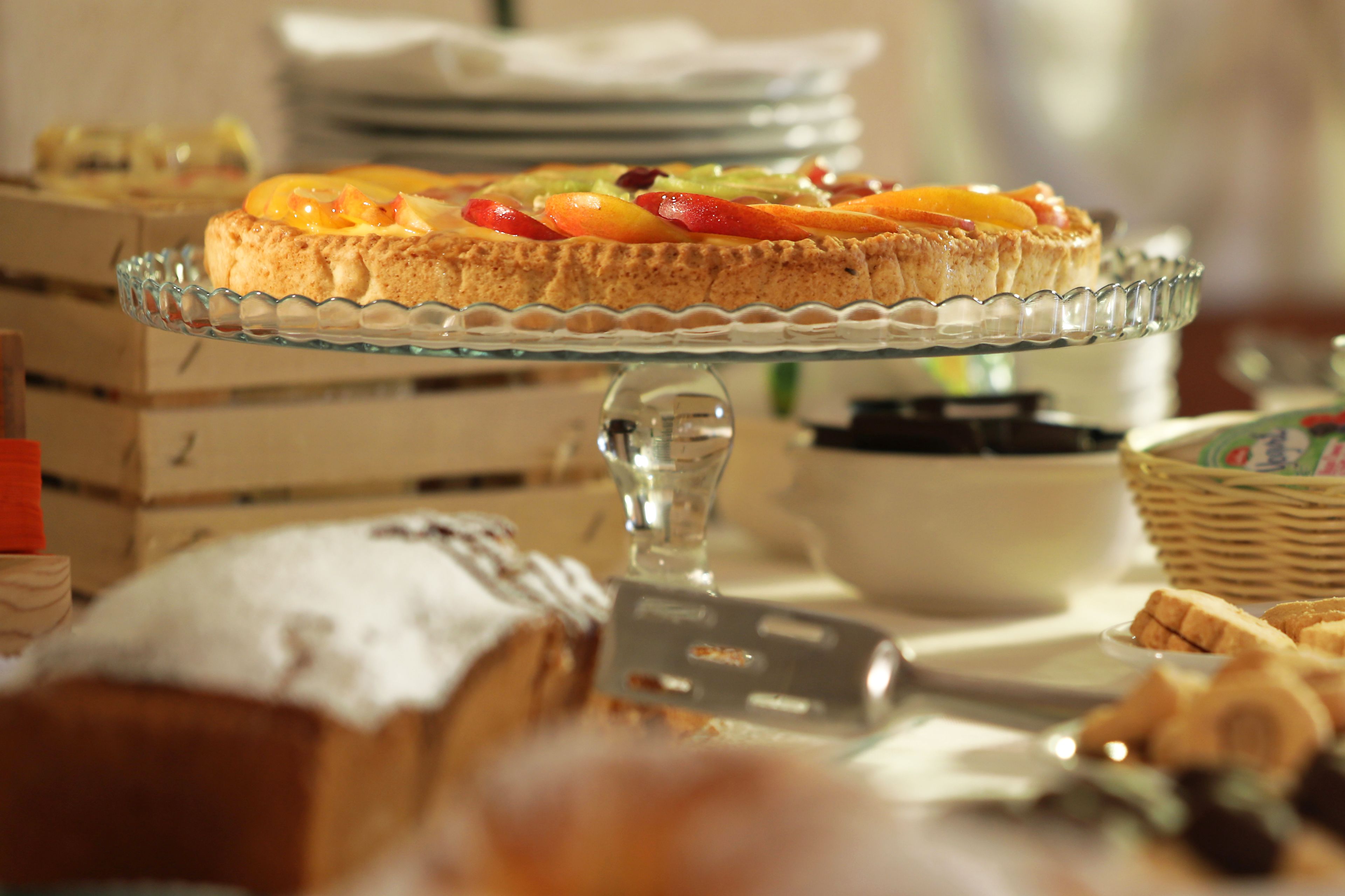 A dessert table with a variety of pastries and a fruit-topped tart.