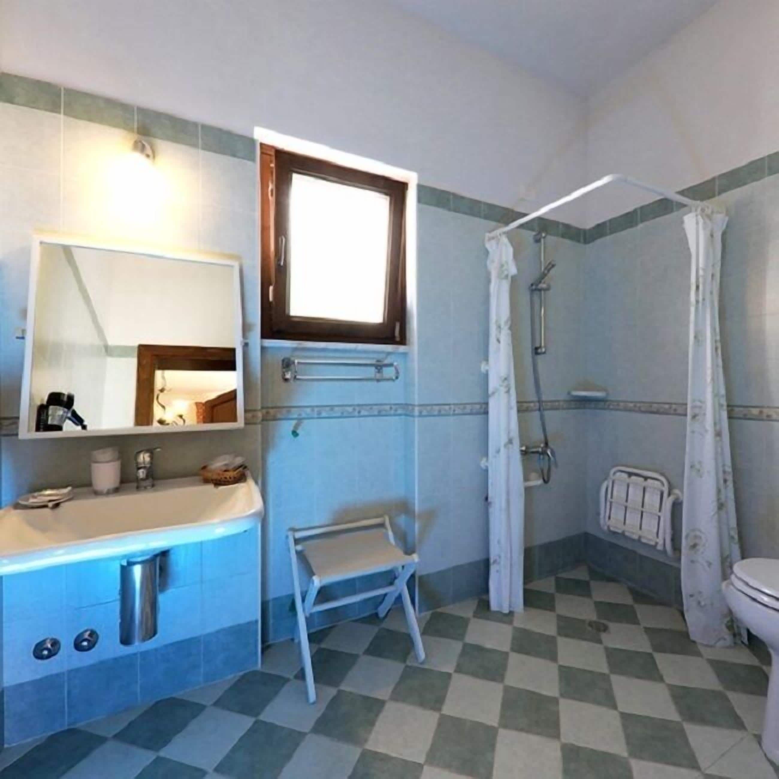 Ein Badezimmer mit Waschbecken, Spiegel, Dusche und Toilette.