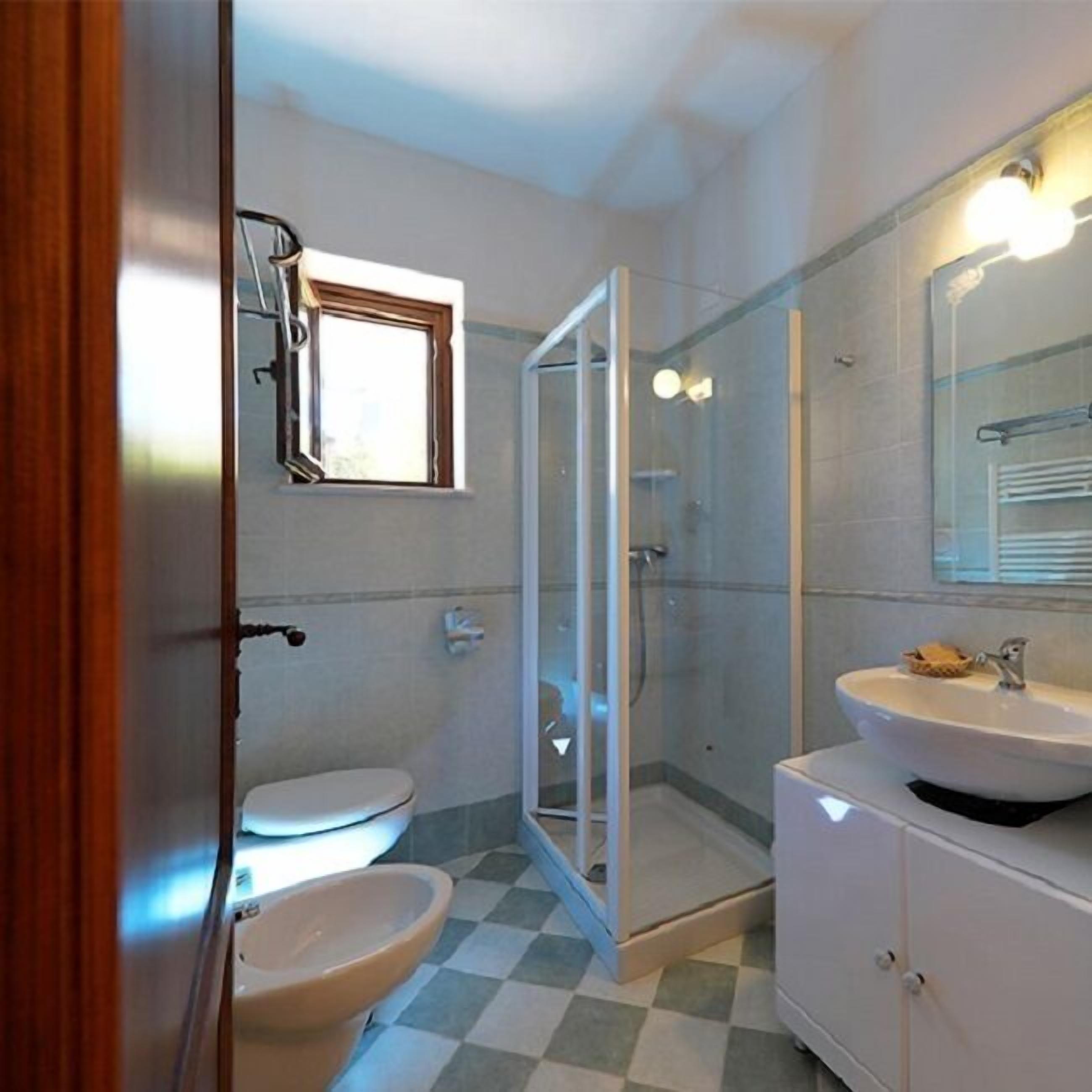 A bathroom with a toilet, a sink, and a shower.