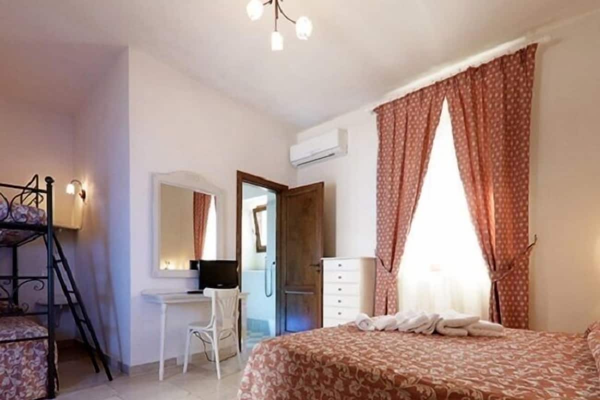 Une chambre à coucher avec un lit, un bureau, une chaise et une armoire.