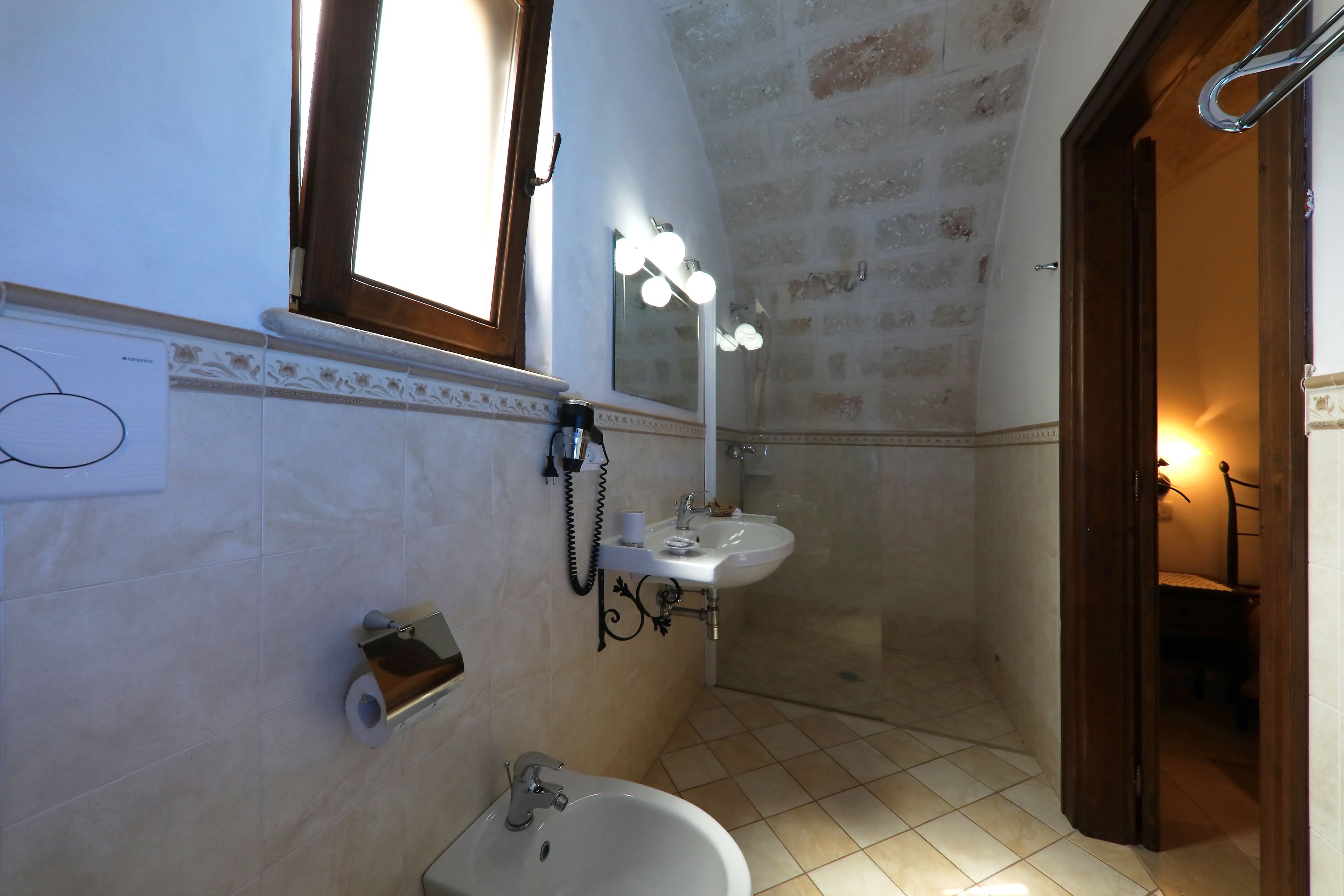 A bathroom with a sink, mirror, and shower.