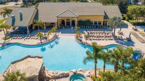 A resort with a large swimming pool, sun loungers, and a building with a tiled roof. - 5BR Disney Pool Home | 3 King Bedrooms | Private Pool, Spa & BBQ | Sleeps 13 (Kissimmee)