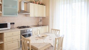 Une cuisine équipée d’un four à micro-ondes, d’une cuisinière, d’un four et d’une table à manger avec des chaises.