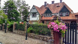 Ein traditionelles Haus im Tudor-Stil mit Steinmauer und Holzpforte.