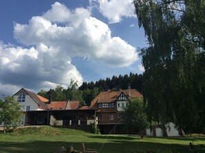 A traditional European-style building with a sloped roof, a visible chimney, and a large window. - Vacation apartment "Wildblick" - Stylish living in a historic ambience  (Mürlenbach)