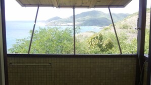 A room with a view of a coastal landscape, including hills and a body of water. - Secluded skytop retreat with stunning sea and mountain Views (Falmouth Harbor)