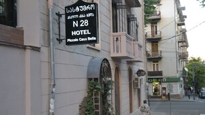 Placa de hotel com texto em árabe e inglês para 'N 28 HOTEL Piccolo Casa Bella'.